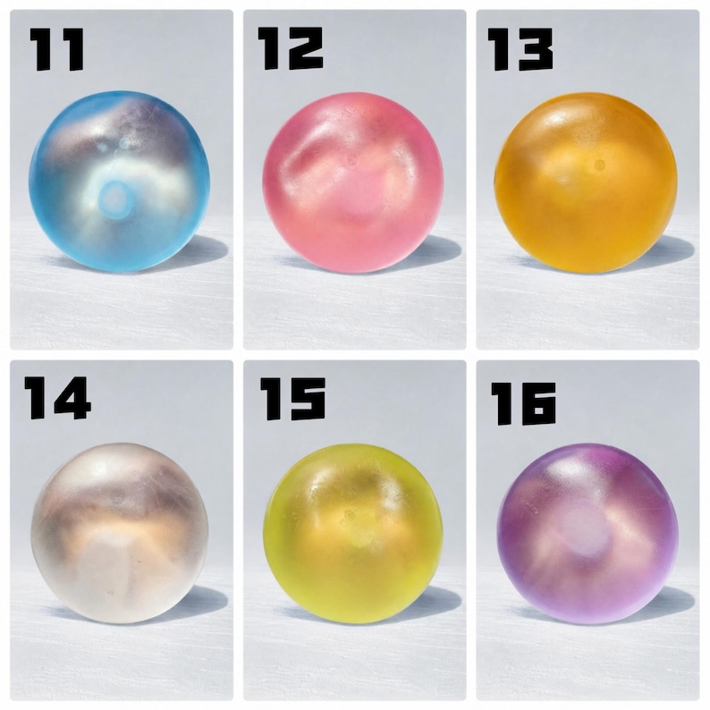 May include: A grid of six translucent, spherical objects labeled 11 through 16. The spheres appear in blue, pink, yellow, white, lime green, and purple. Each smooth, round item casts a distinct shadow, showcasing a glossy, semi-transparent finish.