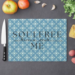 Könnte beinhalten: Ein blaues Schneidebrett aus Glas mit einem weißen Schneeflockenmuster. Der Text "Soulfree time out ME" ist in Schwarz auf dem Brett gedruckt.