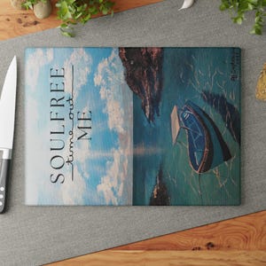 Könnte beinhalten: Ein blaues und grünes Gemälde eines Bootes im Wasser mit einem bewölkten Himmel und dem Text "SOULFREE -time out- ME" auf der linken Seite des Bildes.