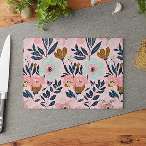 Könnte beinhalten: Ein rosa Schneidebrett mit floralem Muster und dem Text "Soulfree Home Goods" in Schwarz.