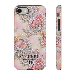 Könnte beinhalten: Eine rosa und silberne Handyhülle mit Blumenmuster und dem Text "Soulfree Time Out Me".