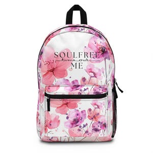 Könnte beinhalten: Ein weißer Rucksack mit einem rosafarbenen Blumenmuster und dem Text "Soulfree - time out ME".
