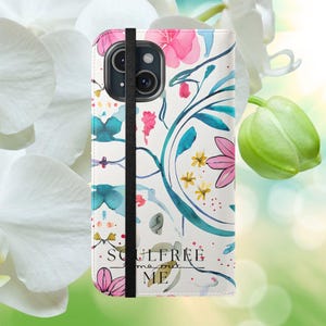 Könnte beinhalten: Eine weiße Handyhülle mit einem Aquarell-Blumenmuster in Rosa-, Blau- und Gelbtönen. Der Text "Soulfree me out me" ist auf der Hülle aufgedruckt.