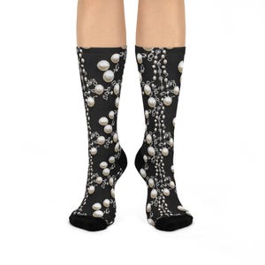 May include: A pair of black socks with a white pearl and chain pattern. The socks are shown on a model's legs.