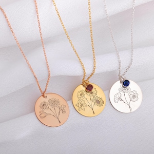 Peut inclure: Trois colliers délicats avec des pendentifs ronds ornés de motifs floraux gravés. Chaque pendentif est orné d'une petite pierre précieuse rouge, bleue et dorée.