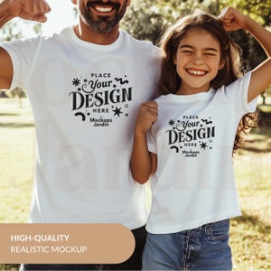 May include: A white t-shirt mockup featuring a father and daughter wearing matching shirts with the text "PLACE YOUR DESIGN HERE Mockups Jardin" printed on the front.
