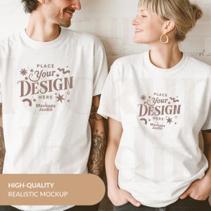 May include: Two white t-shirts with a brown design that says "PLACE *Your* DESIGN HERE Mockups Jardin".