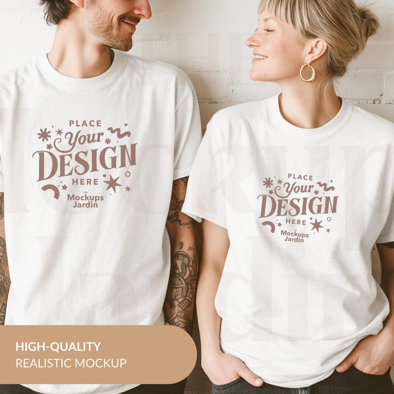 May include: Two white t-shirts with a brown design that says "PLACE *Your* DESIGN HERE Mockups Jardin".