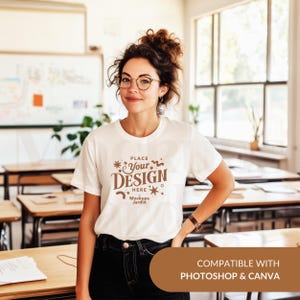 May include: White t-shirt mockup with the text "PLACE YOUR DESIGN HERE Mockups Jardin" in brown text. The t-shirt is being worn by a person in a classroom setting. Compatible with Photoshop and Canva.
