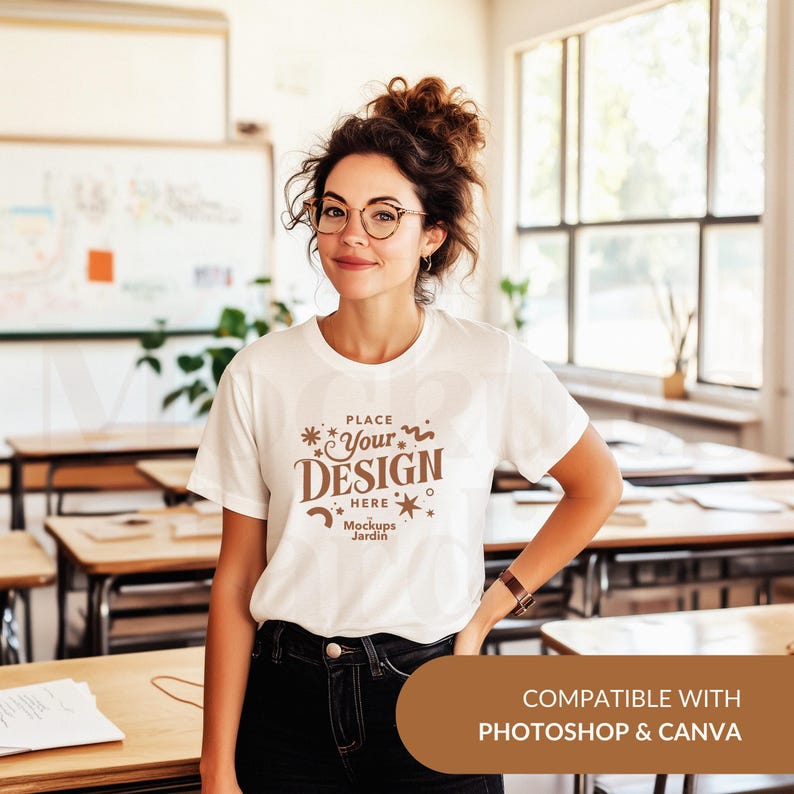 May include: White t-shirt mockup with the text "PLACE YOUR DESIGN HERE Mockups Jardin" in brown text. The t-shirt is being worn by a person in a classroom setting. Compatible with Photoshop and Canva.