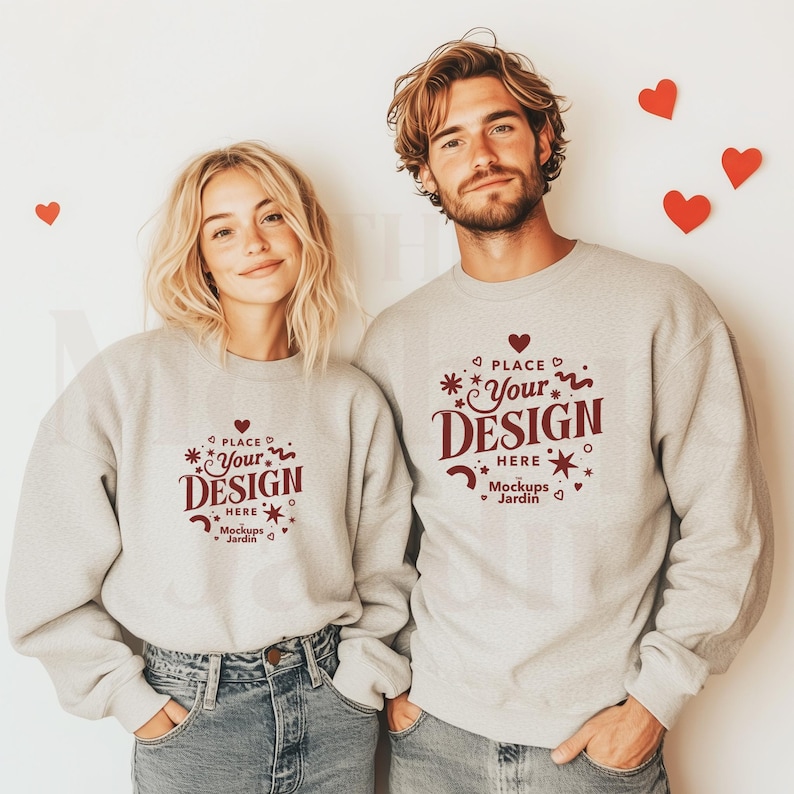 Ash Gildan 18000 Mockup showing a couple in matching sweatshirts standing against beige background with heart shaped decorations.