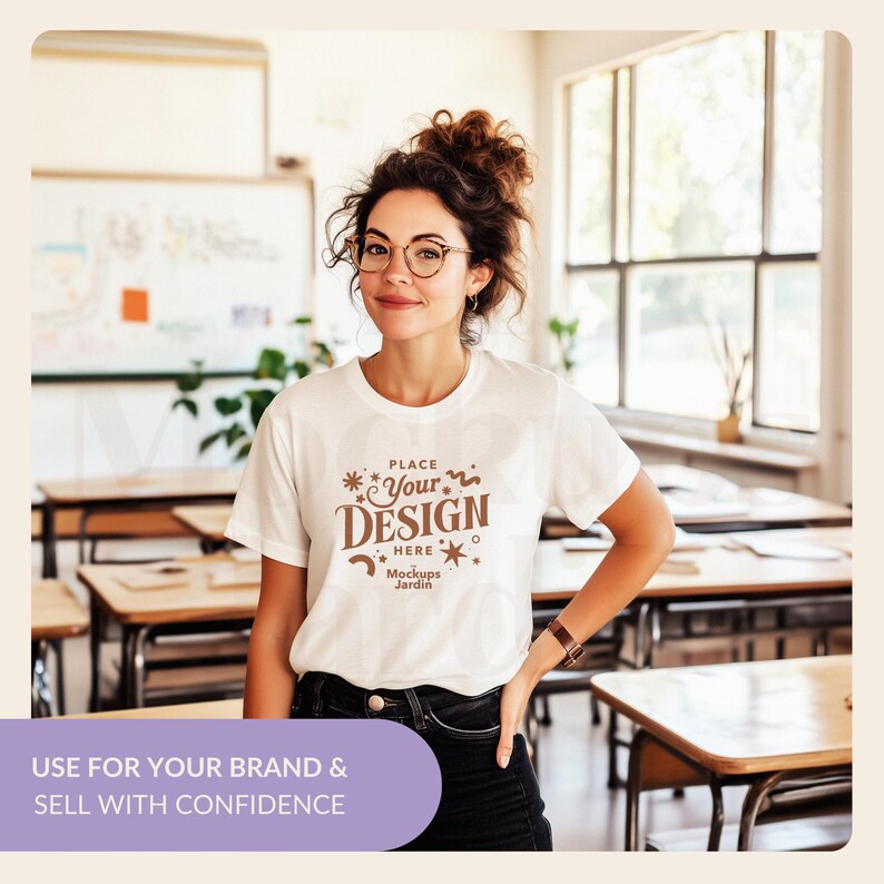 May include: A white t-shirt mockup with a brown design that says "PLACE YOUR DESIGN HERE Mockups Jardin". The t-shirt is being worn by a person in a classroom setting.