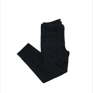 Puede incluir: Vaqueros negros ajustados con un detalle de cremallera en los tobillos.