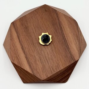 May include: A white ceramic mug with a black handle and the text "But First, Coffee" in a black, handwritten-style font. The mug is on a white surface.