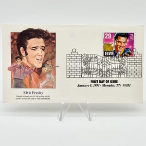 May include: A commemorative envelope featuring a 29-cent Elvis Presley postage stamp, a portrait illustration of the singer, and a line drawing of a brick wall with musical notes. Text includes Elvis Presley, First Day of Issue, and January 8, 1993.
