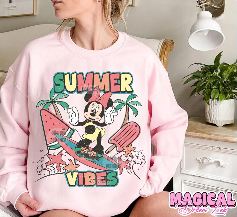May include: Pink sweatshirt with a graphic of Mickey Mouse surfing on a watermelon surfboard. The graphic also includes palm trees, a popsicle, and the text "Summer Vibes".