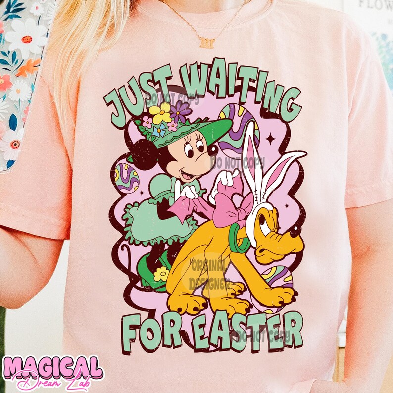 Puede incluir: Camiseta rosa con un gr&aacute;fico de estilo vintage de Mickey Mouse vestido de conejito de Pascua, montando a Pluto. El texto "Just Waiting for Easter" est&aacute; impreso en la camiseta.