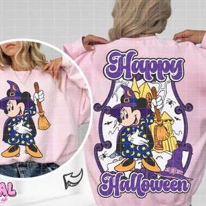 May include: Pink sweatshirt featuring a cartoon Mickey Mouse dressed as a witch, holding a broom. The back of the sweatshirt has a graphic with the words "Happy Halloween". The design includes a haunted house and a witch's hat.
