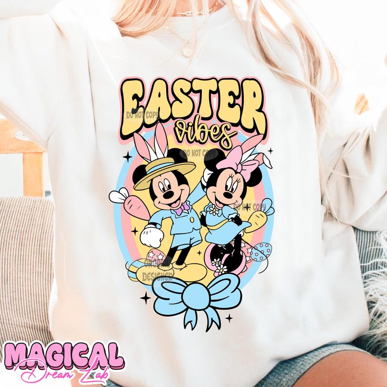 May include: White sweatshirt with a colorful graphic of Mickey Mouse and Minnie Mouse dressed in Easter outfits. The graphic includes the text "Easter vibes".