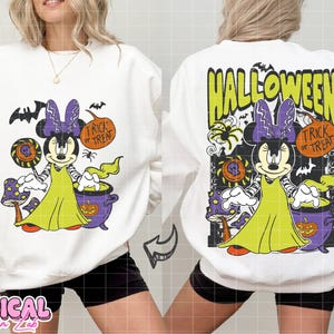 Może przedstawiać: Biała bluza na Halloween z grafiką Minnie Mouse w kostiumie czarownicy. Projekt zawiera nietoperze, kocioł i napis "Trick or Treat". Z tyłu bluzy napis "Halloween".