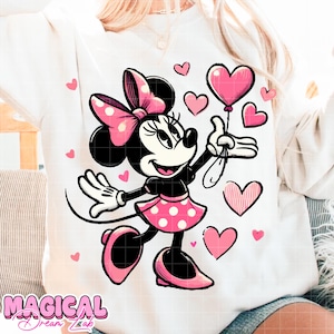 Puede incluir: Sudadera blanca con un dise&ntilde;o de Minnie Mouse. Minnie lleva un lazo, falda y zapatos de lunares rosas, sosteniendo un globo en forma de coraz&oacute;n rosa, rodeada de corazones rosas. El texto "MAGICAL Dream Lab" est&aacute; en la parte inferior.