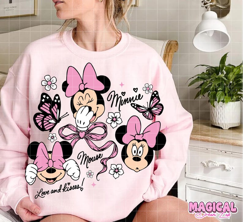 Peut inclure: Un sweat-shirt rose clair avec des graphiques de Minnie Mouse. Le design comprend le visage de Minnie, des n&oelig;uds, des papillons, des fleurs et les mots "Minnie", "Mouse" et "Love and kisses!".