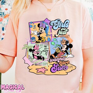 May include: Pink t-shirt with a graphic design featuring Mickey Mouse and Minnie Mouse in a summery scene. The text "Girls just wanna have sun" is featured on the design.