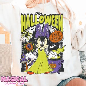 Może przedstawiać: Biała bluza z grafiką o tematyce Halloween. Projekt zawiera postać z kresk&oacute;wki Minnie Mouse przebraną za czarownicę, zielony napis "HALLOWEEN" i dymek "Trick or Treat". Dodatkowe elementy: pająk, kocioł i grzyby.