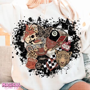 May include: White sweatshirt with a graphic design featuring a skull with flames, a butterfly, an 8-ball, a cowboy hat, a leopard, and Route 66 imagery. The design is surrounded by black paint splatters.