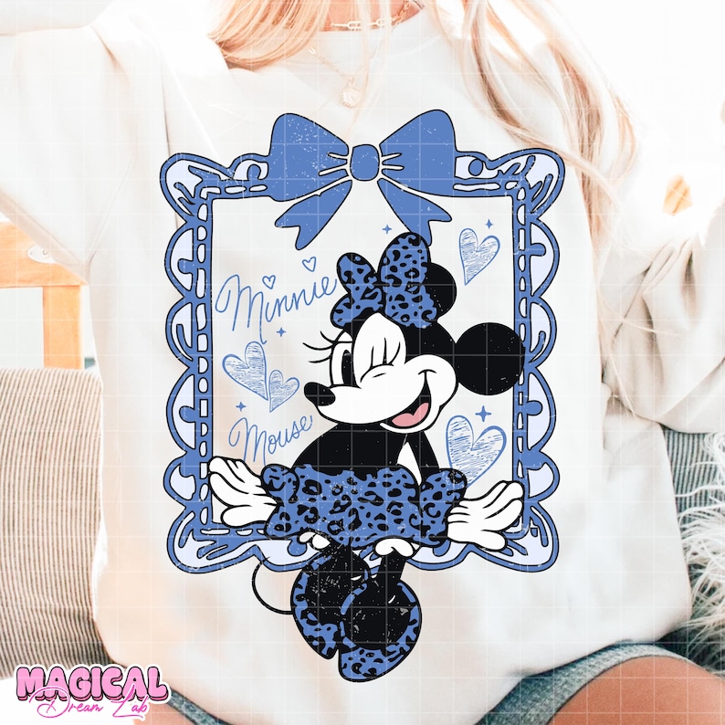 May include: White sweatshirt featuring a Minnie Mouse graphic in a blue frame with a bow and hearts. The Minnie Mouse design includes a blue leopard print bow and dress, with the words "Minnie Mouse" in cursive.