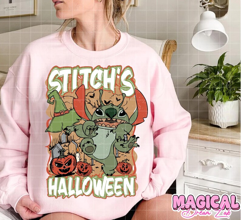May include: Pink sweatshirt featuring a Halloween-themed graphic of Stitch, a green alien character, with a witch hat, pumpkins, and the text "Stitch's Halloween". The design is in orange, green, and brown.