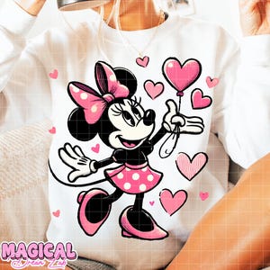 Puede incluir: Sudadera blanca con un dise&ntilde;o de Minnie Mouse. Minnie est&aacute; representada en negro, rosa y blanco, sosteniendo un globo en forma de coraz&oacute;n rosa. Corazones rosas est&aacute;n dispersos alrededor del personaje. La sudadera tiene el texto "MAGICAL Dream Lab".