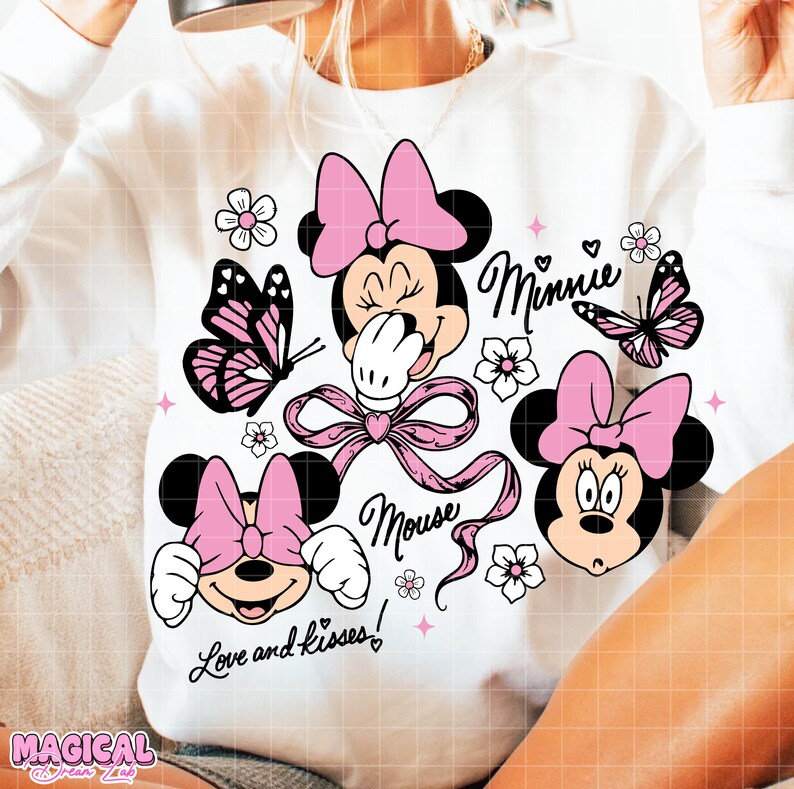 Peut inclure: Sweat-shirt blanc orn&eacute; de motifs Minnie Mouse avec des n&oelig;uds roses, des papillons et des fleurs. Le design comprend le texte "Minnie Mouse" et "Love and kisses!" dans une police fantaisiste. Un design ludique et color&eacute;.