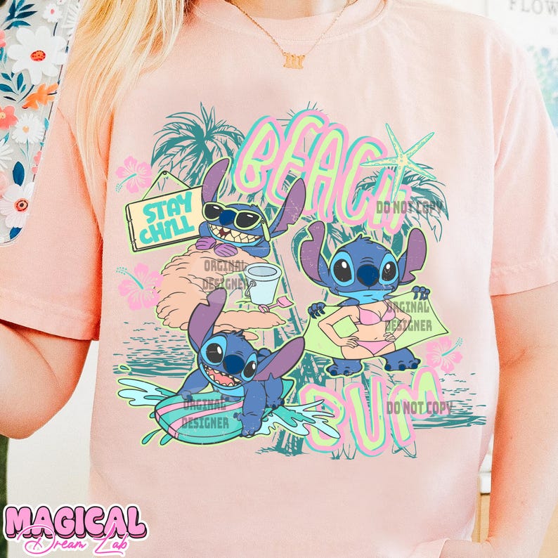 May include: A light pink t-shirt featuring a colorful graphic of the character Stitch at the beach. The design includes the words "BEACH SUN" and "STAY CHILL". The shirt has short sleeves and a crew neck.