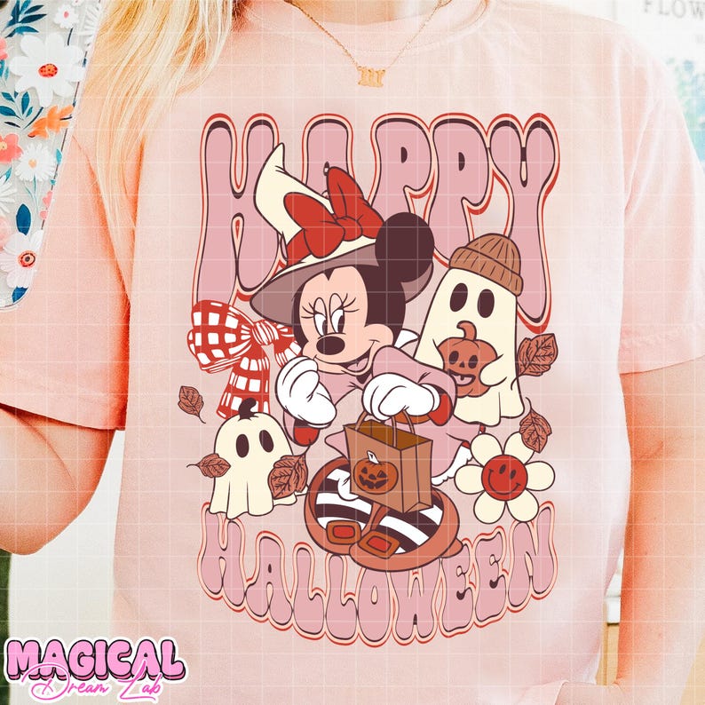 K&ouml;nnte beinhalten: Hellrosa T-Shirt mit einem Cartoon-Motiv von Minnie Mouse mit Hexenhut, die eine Trick-or-Treat-Tasche h&auml;lt, und den Worten "Happy Halloween". Das Design umfasst Geister, K&uuml;rbisse und Herbstbl&auml;tter.