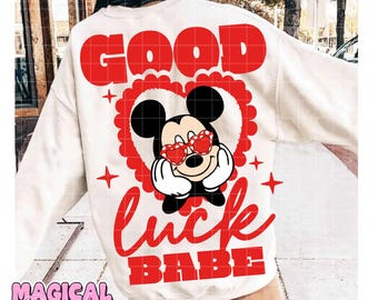 Può includere: Felpa color crema con un design a forma di cuore rosso e Topolino con occhiali da sole a forma di cuore. Le parole "GOOD" e "LUCK BABE" sono rosse. Il testo "MAGICAL Dream Lab" è in basso.