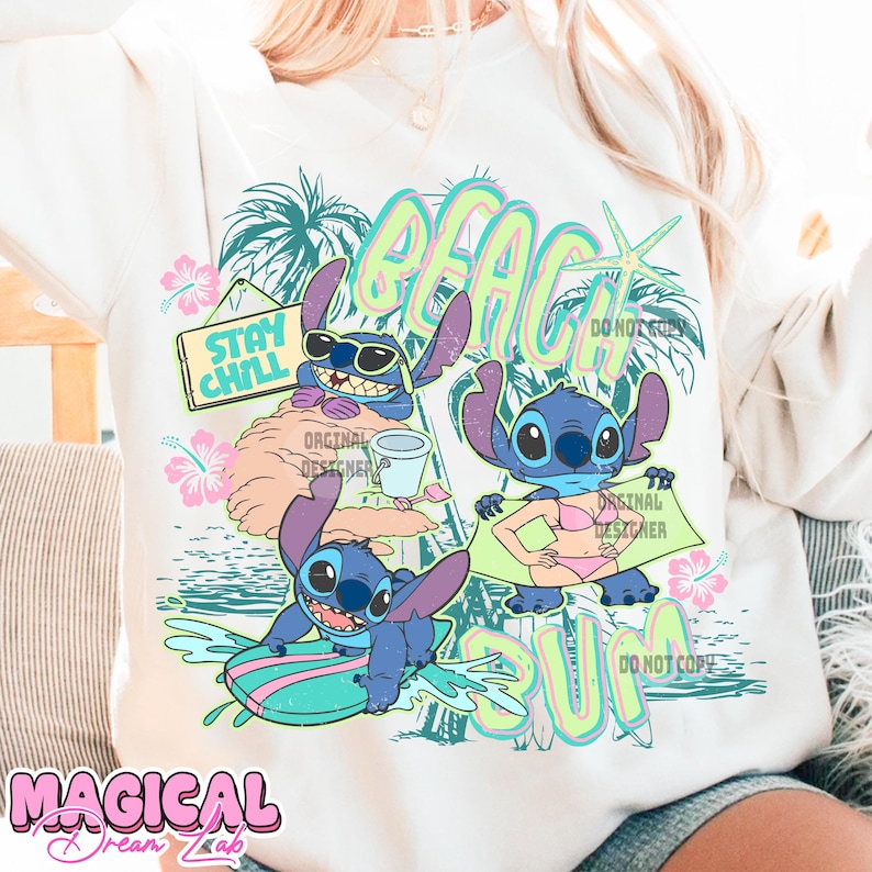 May include: A cream-colored sweatshirt featuring a colorful graphic of the character Stitch at the beach. The design includes the words "Beach Bum" and "Stay Chill", along with tropical elements like palm trees and hibiscus flowers.
