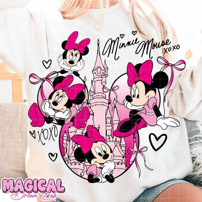 May include: White sweatshirt featuring Minnie Mouse illustrations in pink and black. The design includes Minnie Mouse characters, a castle, hearts, and the text "Minnie Mouse xoxo" in black script. The words "Magical Dream Lab" are also visible.