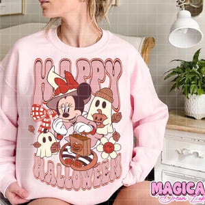 K&ouml;nnte beinhalten: Hellrosa Sweatshirt mit einem Retro-Grafik-Design mit der Aufschrift "Happy Halloween". Das Design zeigt Minnie Mouse mit Hexenhut, Geister, K&uuml;rbisse und Blumen in Braun-, Orange- und Wei&szlig;t&ouml;nen.