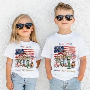 May include: Two white short-sleeve t-shirts featuring a graphic of Toy Story characters in front of a distressed American flag. The text reads 1776-2026 and America-250th Anniversary. The design includes Woody, Buzz Lightyear, Jessie, Rex, Hamm, and Mr. Potato Head.