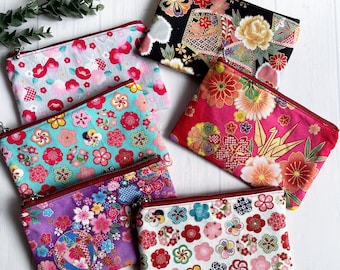 Nécessaire de maquiagem japonesa com zíper e estampa floral, feita em tecido de algodão com padrão de sakura, ume e temari (garça), ideal para presentear do Japão. Feita em tecido japonês, também conhecida como tecido para quimono.