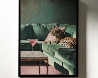 Pode incluir: Uma impressão de arte emoldurada com um leopardo descansando em um sofá de veludo verde com almofadas rosa. Um coquetel está em uma pequena mesa. O fundo é uma parede verde escura.