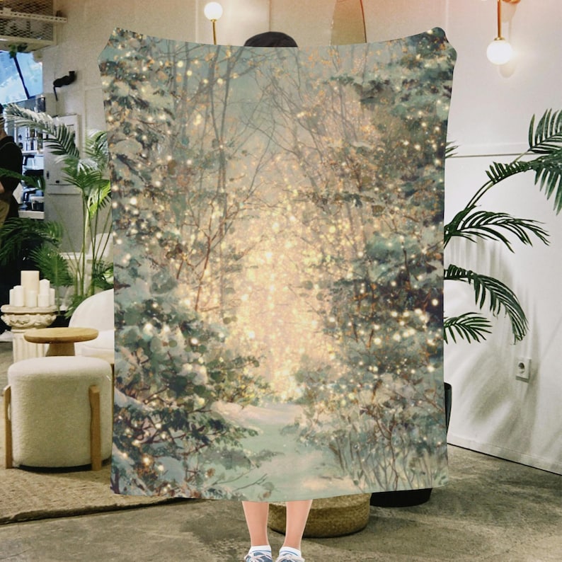 May include: A cozy blanket featuring a winter forest scene with snow-covered trees and a path leading into the light. The design includes soft, muted colors and twinkling lights, creating a warm and inviting atmosphere. This blanket is perfect for snuggling up during the colder months.
