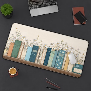 May include: A rectangular desk mat featuring a bookshelf design with colorful books and white daisy flowers. The mat includes a wooden shelf, a white computer mouse, and a variety of office supplies.