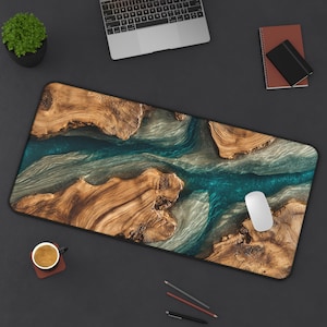May include: A rectangular mouse pad with a wood and resin design. The pad features a river-like pattern with brown wood sections and a teal-colored resin river. A white mouse sits on the pad, with a laptop, notebook, and coffee cup nearby.