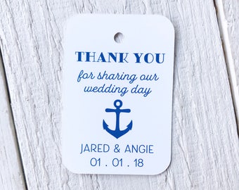 May include: White tag with rounded corners, featuring blue text and an anchor graphic. The tag reads "THANK YOU for sharing our wedding day" and includes the names "JARED & ANGIE" and the date "01.01.18".