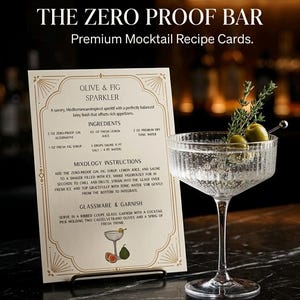 May include: A recipe card for an Olive & Fig Sparkler mocktail, with a cocktail glass garnished with olives and thyme. The card reads "The Zero Proof Bar" and includes ingredients and instructions for the drink.