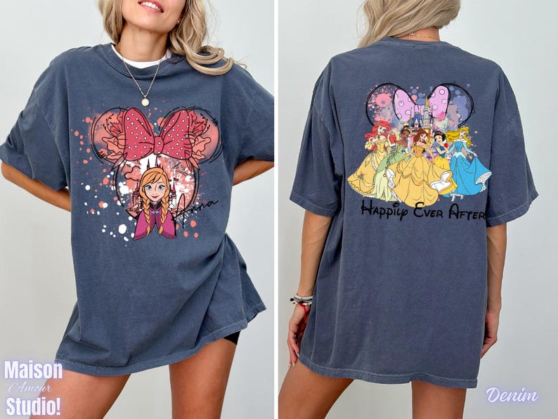 May include: Denim blue t-shirt featuring a Minnie Mouse-shaped design with Anna from Frozen, a pink bow, and the name "Anna". The back of the shirt displays Disney princesses with the text "Happily Ever After".