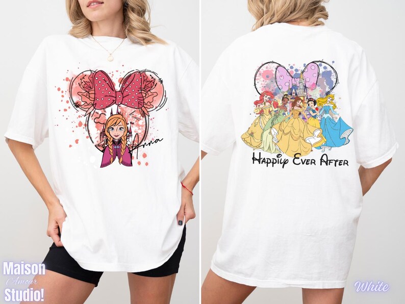 May include: White t-shirt featuring a Minnie Mouse-inspired design with Anna from Frozen on the front. The back of the shirt displays Disney princesses and the text "Happily Ever After". The shirt has short sleeves and a relaxed fit.
