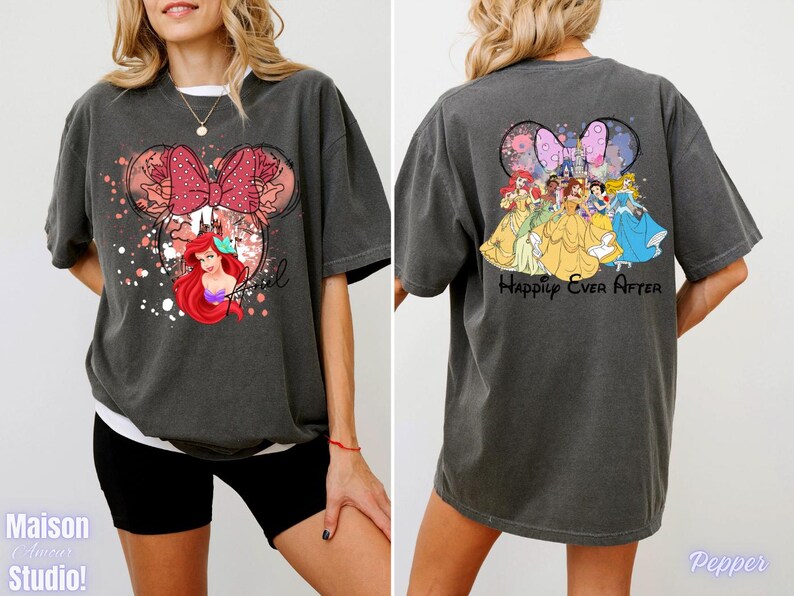 May include: Dark gray t-shirt featuring a Minnie Mouse design with a red bow, floral accents, and Ariel. The back of the shirt displays Disney princesses and the text "Happily Ever After".